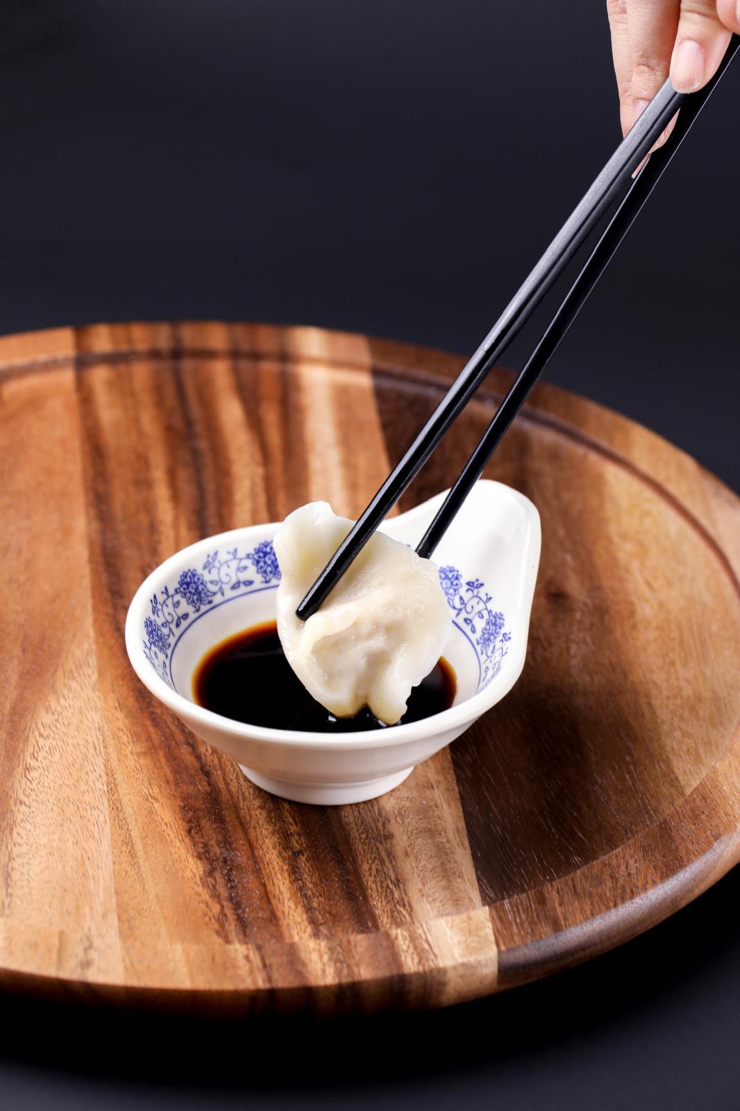 Plant-based mushroom dumplings served with dipping sauce and fresh herbs