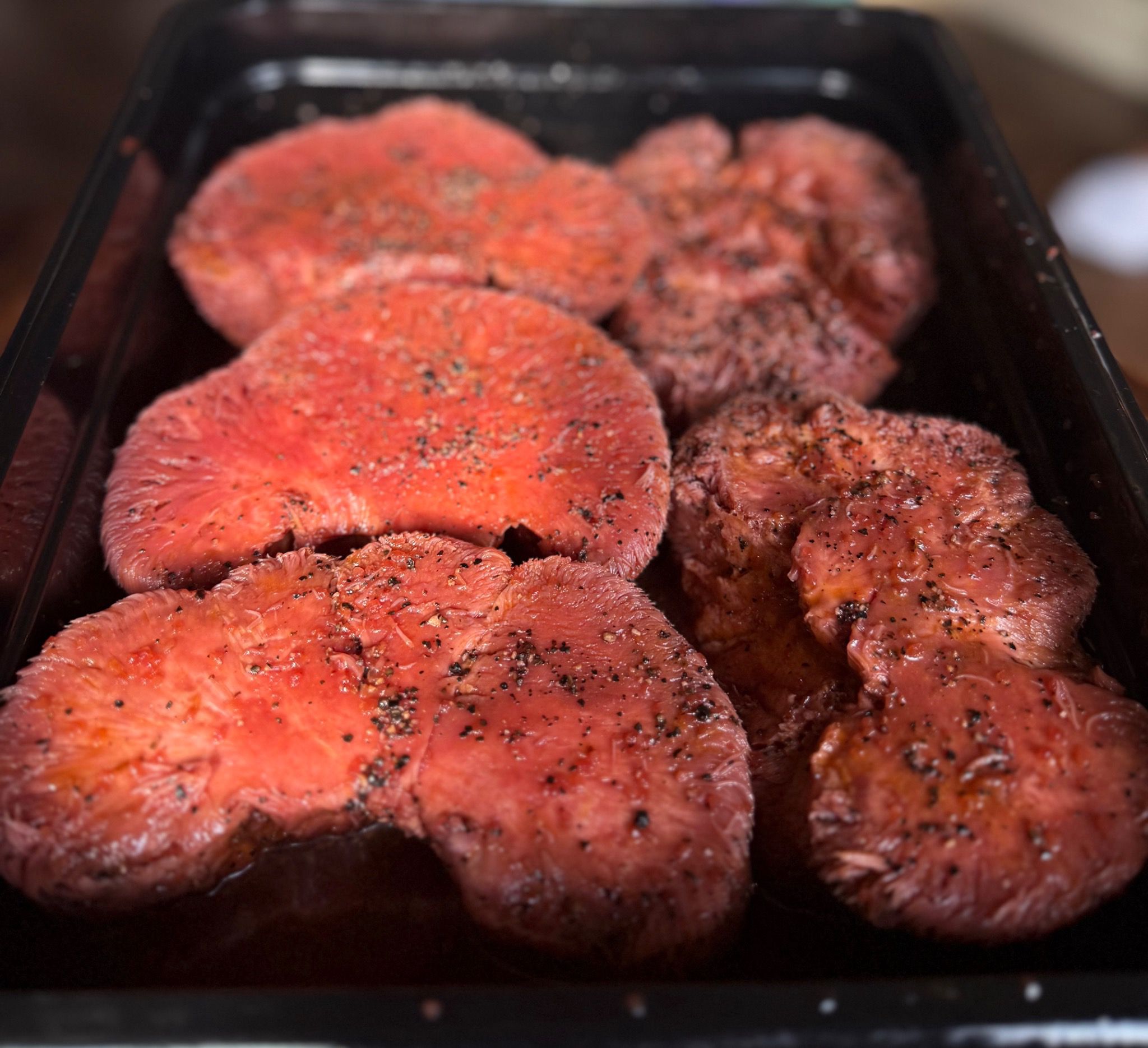 Steaks de champignons Lion’s Mane végétaux servis avec des herbes aromatiques et des légumes rôtis.